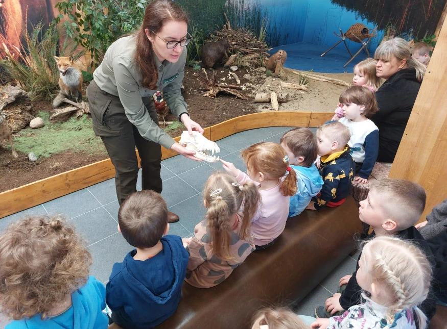 Dzieci z przedszkola anglojęzycznego w Szczecinku oglądają czaszkę zwierzęcia podczas zajęć przyrodniczych.